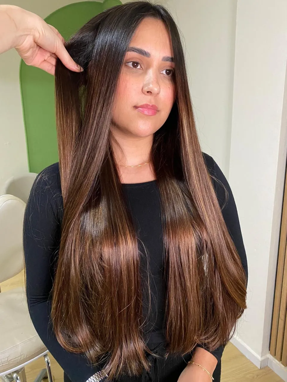 Cliente com cabelo longo e liso em tons de castanho e cobre, no studio